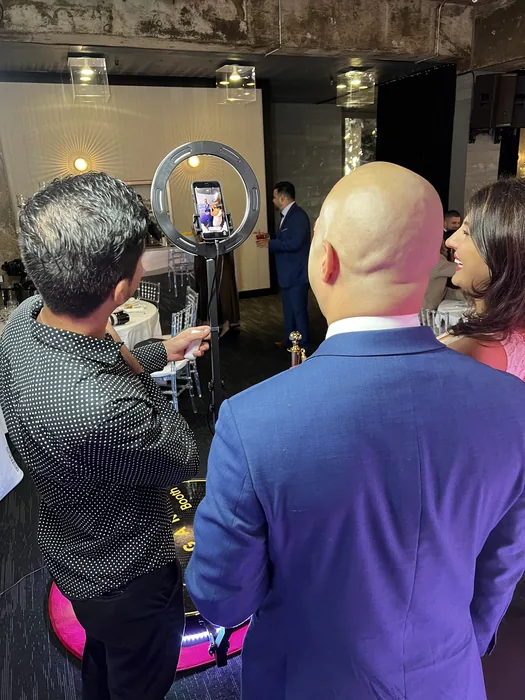 Invitada revisa su video junto al photobooth 360