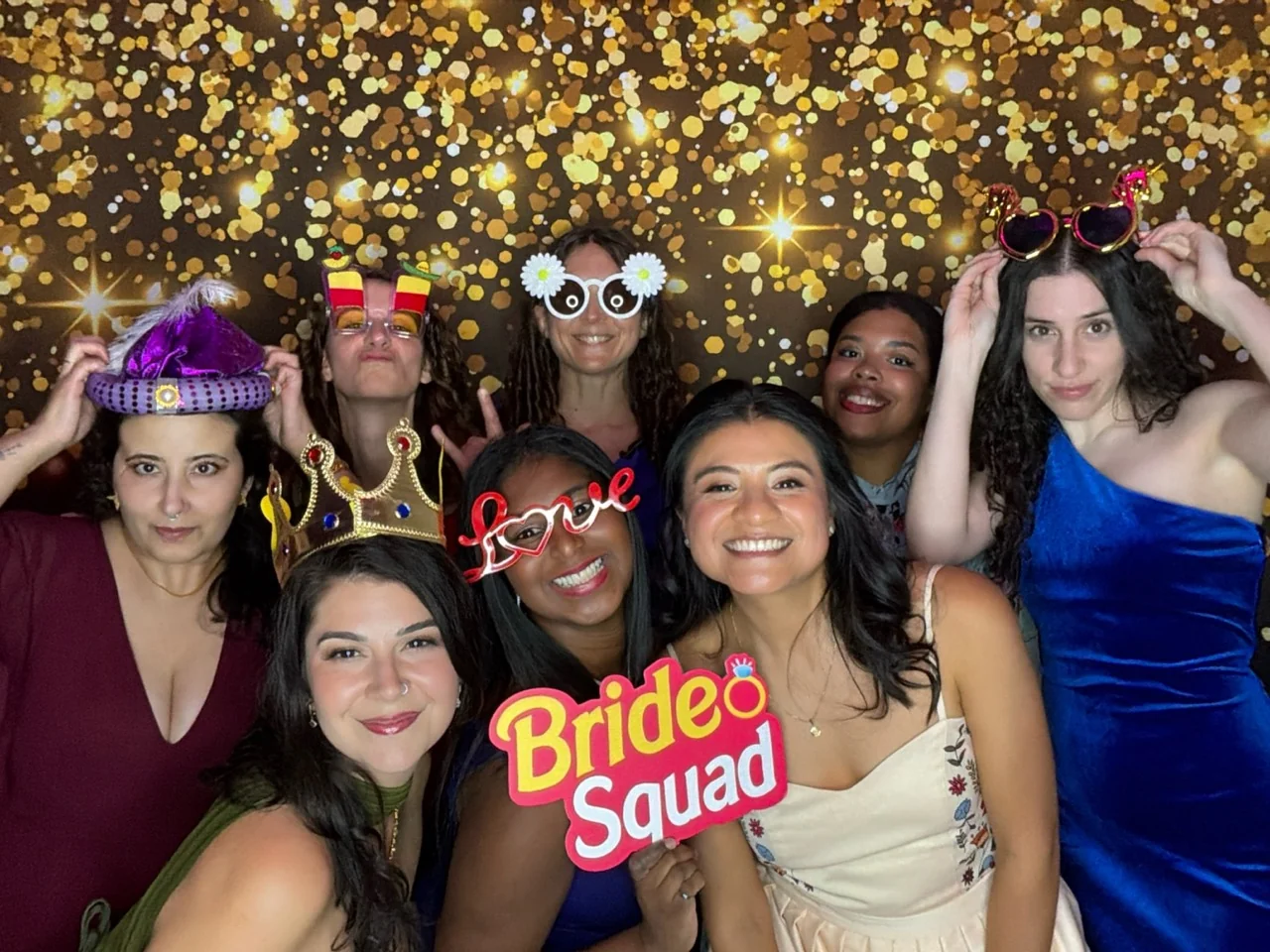 Bride and friends pose with a Bride Squad sign at a Coral Gables wedding photo booth