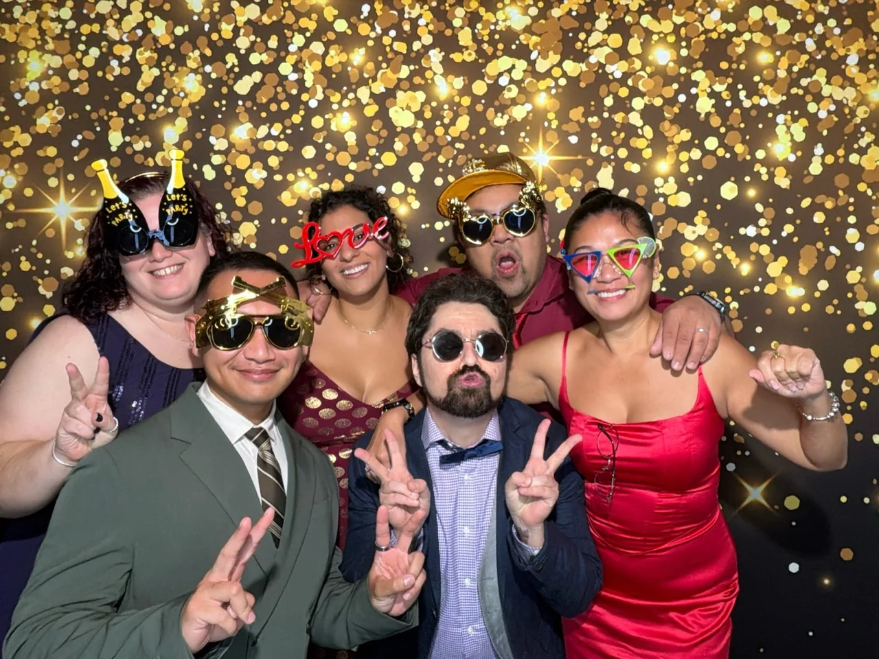 Wedding guests pose with playful glasses in a Digital Photo Booth in Coral Gables