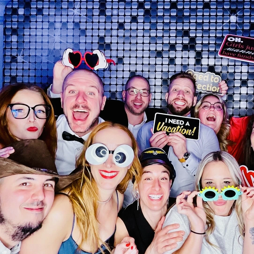 Colegas riéndose juntos con accesorios en el photobooth durante un evento corporativo en Miami