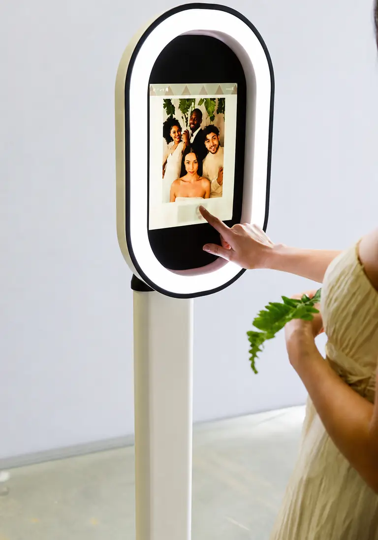El photobooth sin operador en su base, usado por una invitada sin nadie asistiendo
