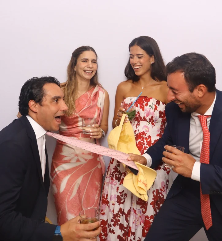 Invitados riéndose y posando juntos frente al photobooth de Eleganza durante un evento