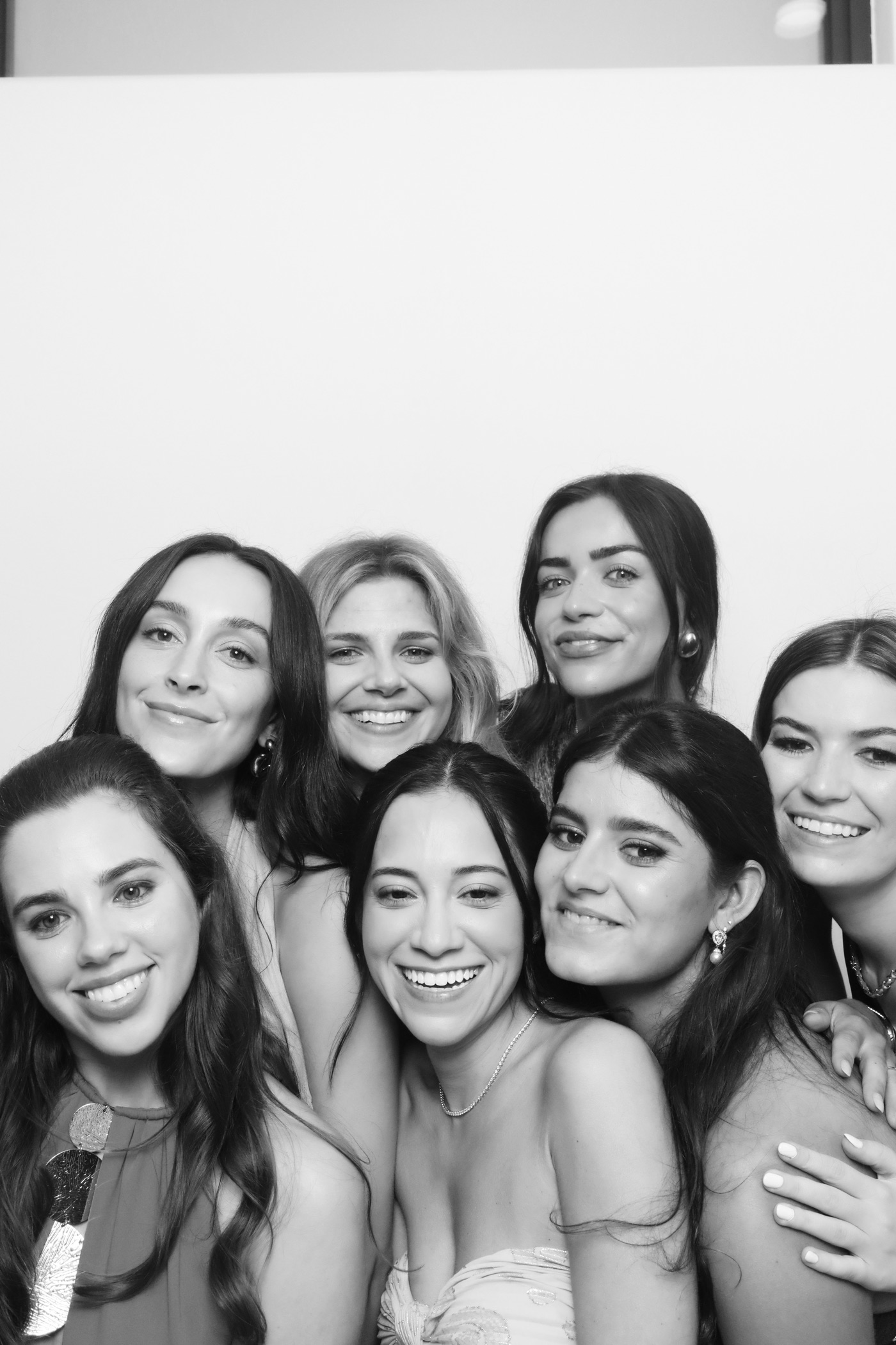 Friends smiling in a black-and-white Glam booth portrait