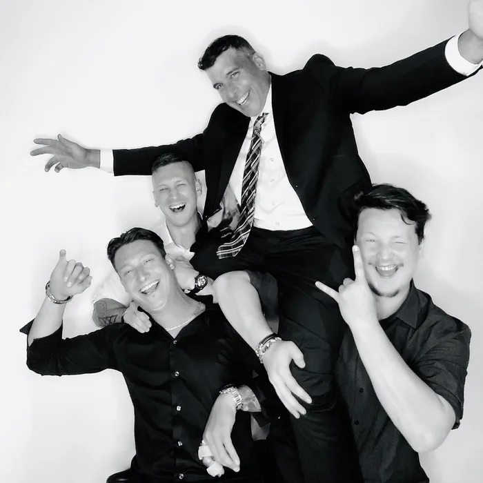 Groomsmen laughing together in a Miami Glam booth portrait