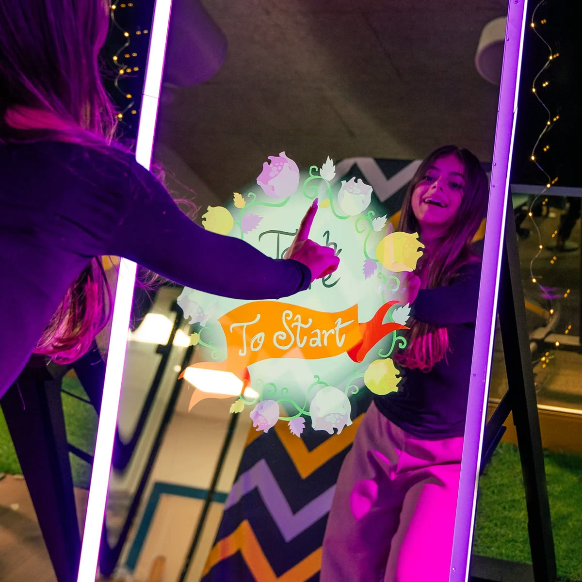 Invitada tocando la pantalla interactiva del Photobooth Espejo Mágico