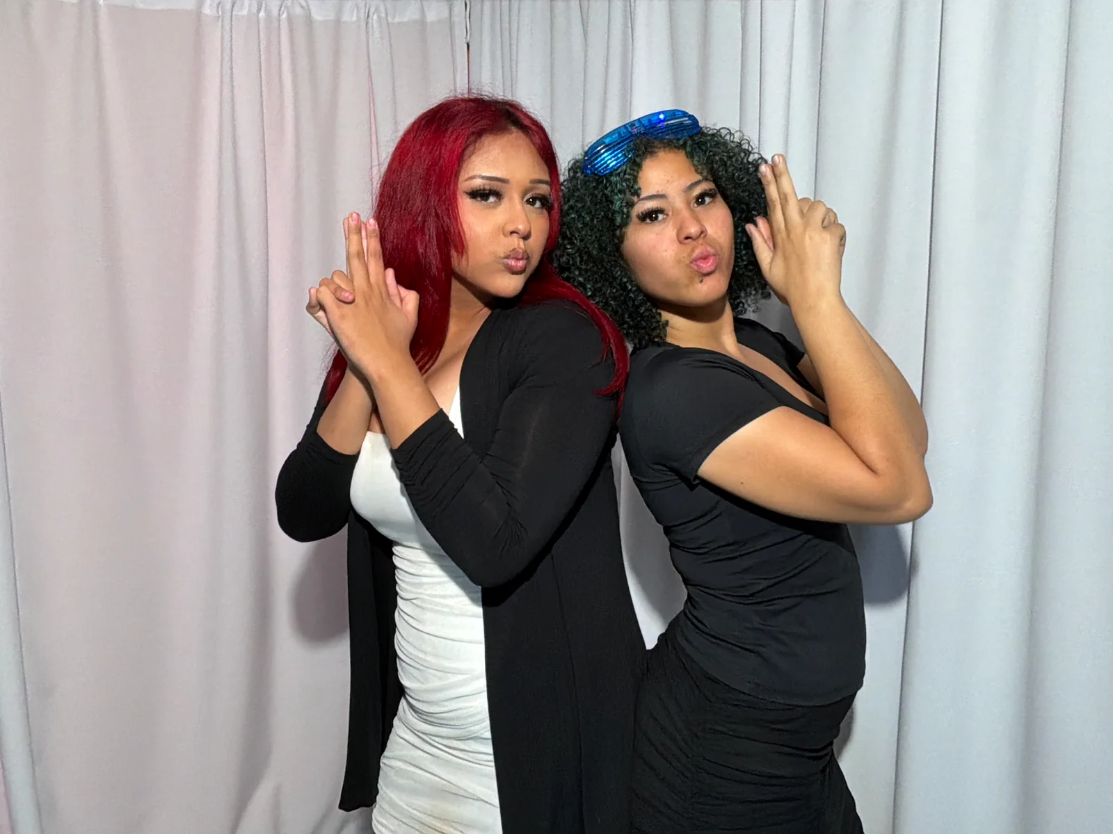 Dos amigas posan en el Photobooth de Autoservicio durante una quinceañera en Miami Beach