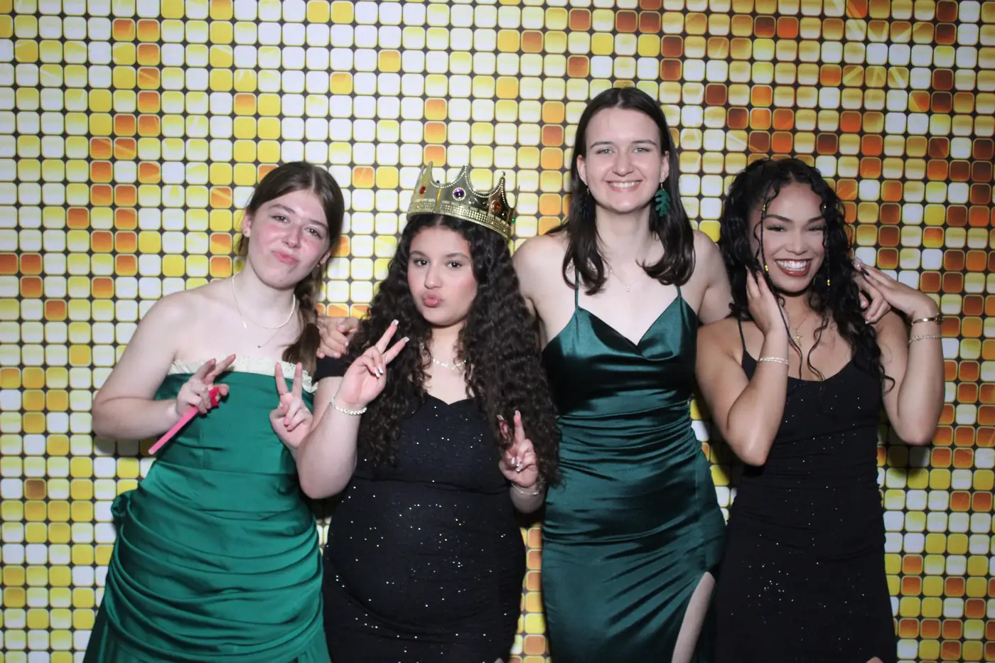 Amigas con vestidos de prom posando juntas en el photobooth