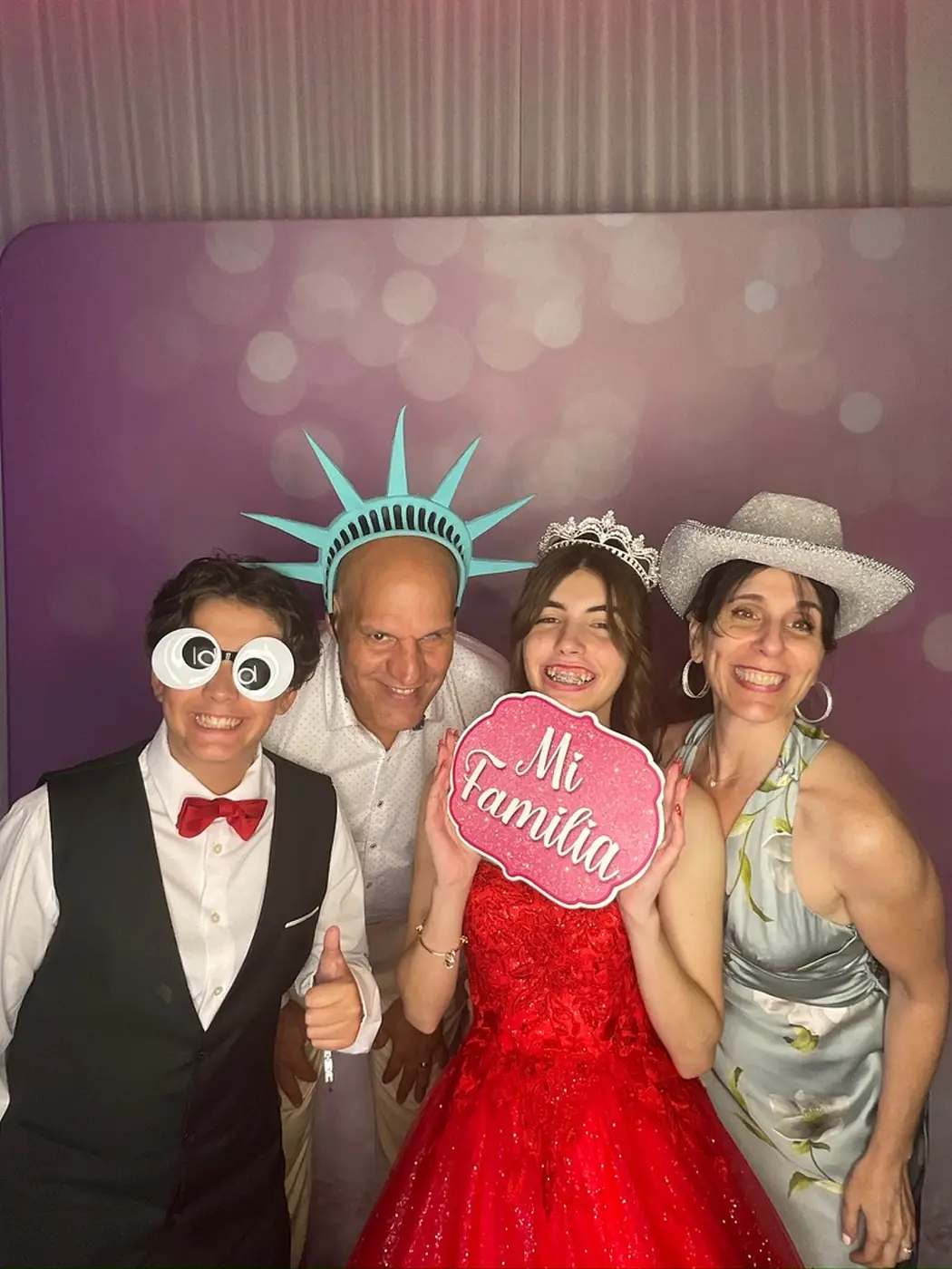 La quinceañera con su familia en el photobooth en Miami, con un letrero de Mi Familia