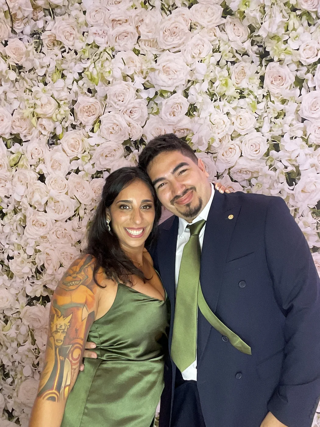 Una pareja en el photobooth con fondo floral en una boda en Aventura