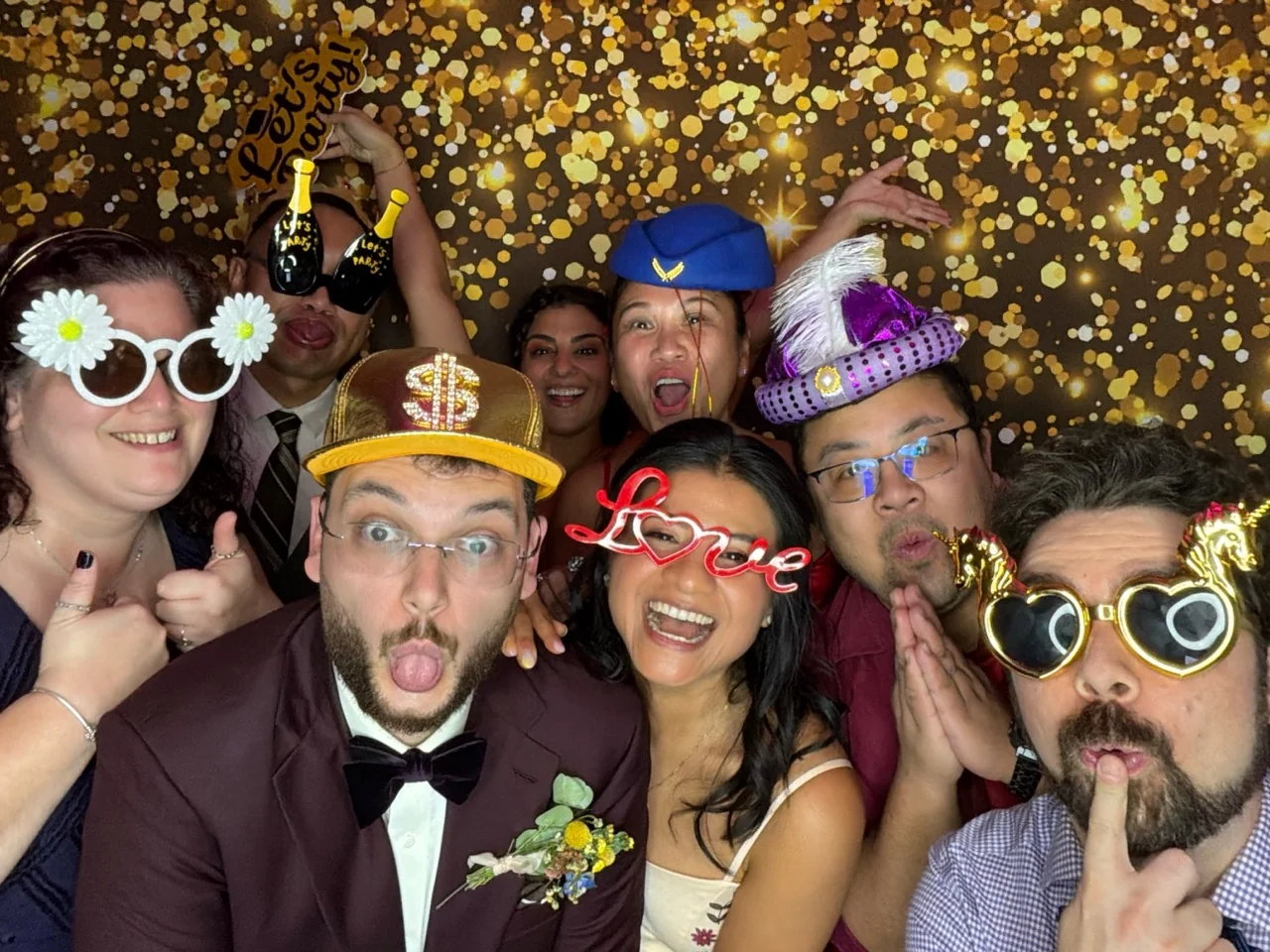 Newlyweds and friends take a playful group photo in the Digital Photo Booth