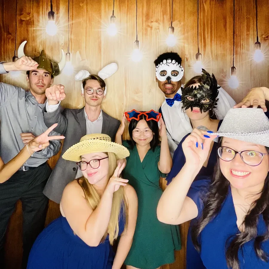 Invitados en el photobooth con fondo dorado bokeh en una boda en Miami