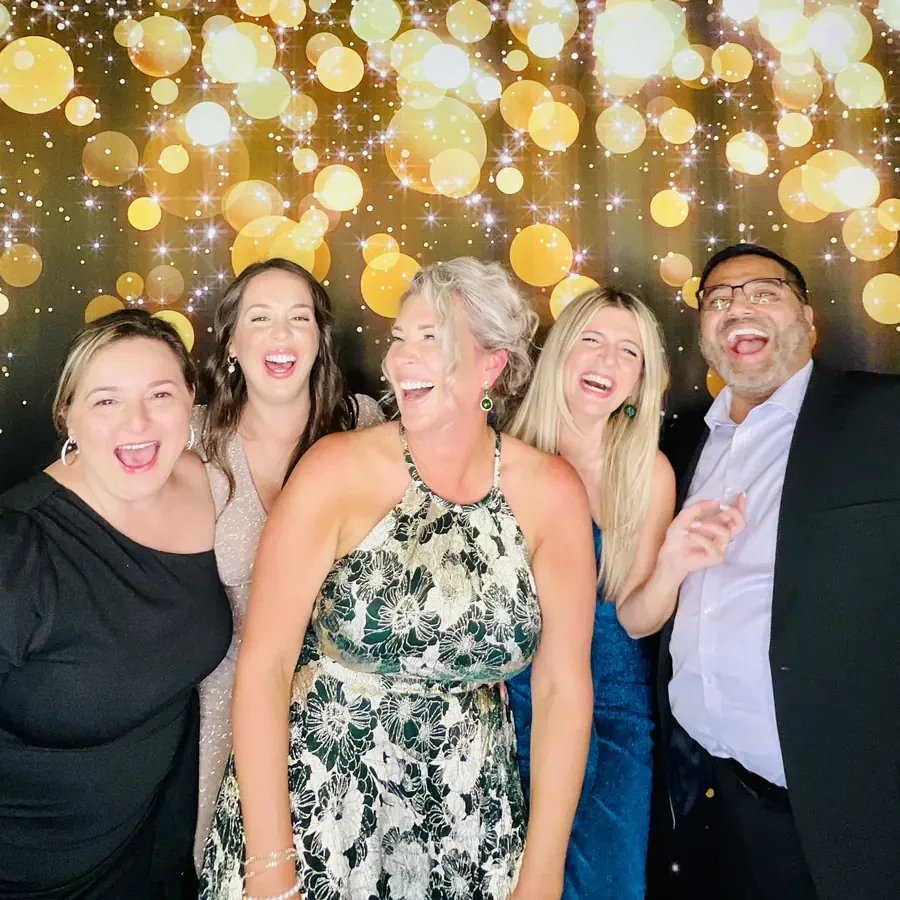 Los novios en el photobooth con fondo de lentejuelas doradas en Miami